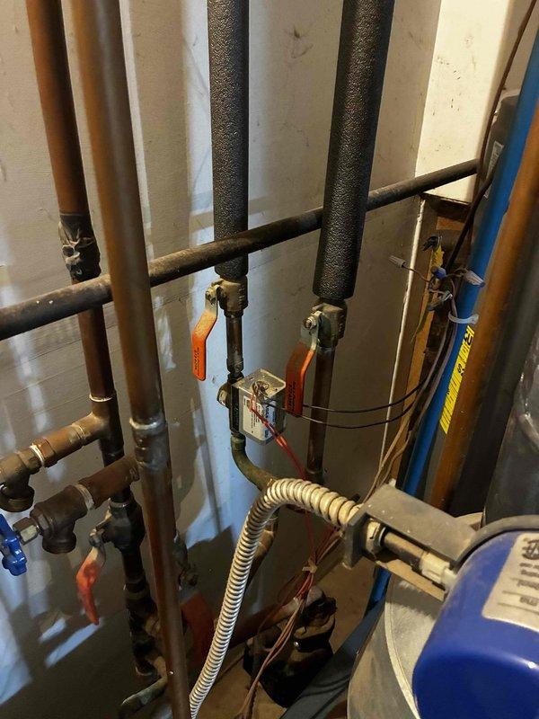 Responded to no cooling complaint on aging HVAC system. Found unit low on refrigerant and condensate drain line completely plugged, preventing proper operation. Recharged system to manufacturer specifications, verified proper airflow across evaporator coil, and cleared drain line obstruction by blowing through tubing to restore drainage. System restored to normal cooling operation with all components functioning properly.