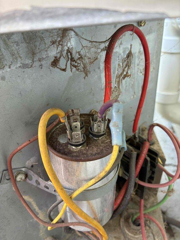 Responded to low cooling complaint on residential air conditioning system. Upon inspection, found heavily corroded and rusted capacitor with significant deterioration on terminals and mounting hardware. Replaced failed capacitor with new unit, ensuring proper wire connections and secure mounting. Tested system operation and confirmed restoration of normal cooling function.