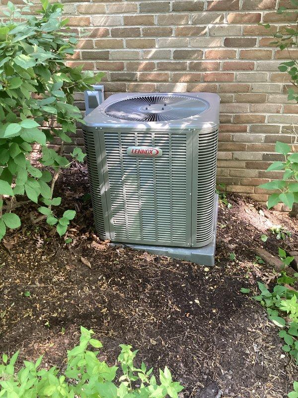 Completed annual maintenance on two air conditioning systems under prepaid quality plan. Performed comprehensive clean and check procedures on both outdoor condenser units. Inspected Lennox condenser positioned against exterior brick wall, removed debris including leaves and twigs from fan grille and top surface. Verified proper operation of both systems with all components functioning within normal parameters. No deficiencies noted and no repairs required at this time.