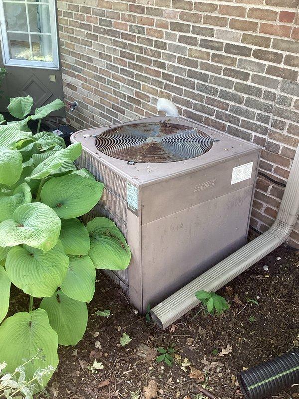 Completed annual maintenance on two air conditioning systems under prepaid quality plan. Performed comprehensive clean and check procedures on both outdoor condenser units. Inspected Lennox condenser positioned against exterior brick wall, removed debris including leaves and twigs from fan grille and top surface. Verified proper operation of both systems with all components functioning within normal parameters. No deficiencies noted and no repairs required at this time.