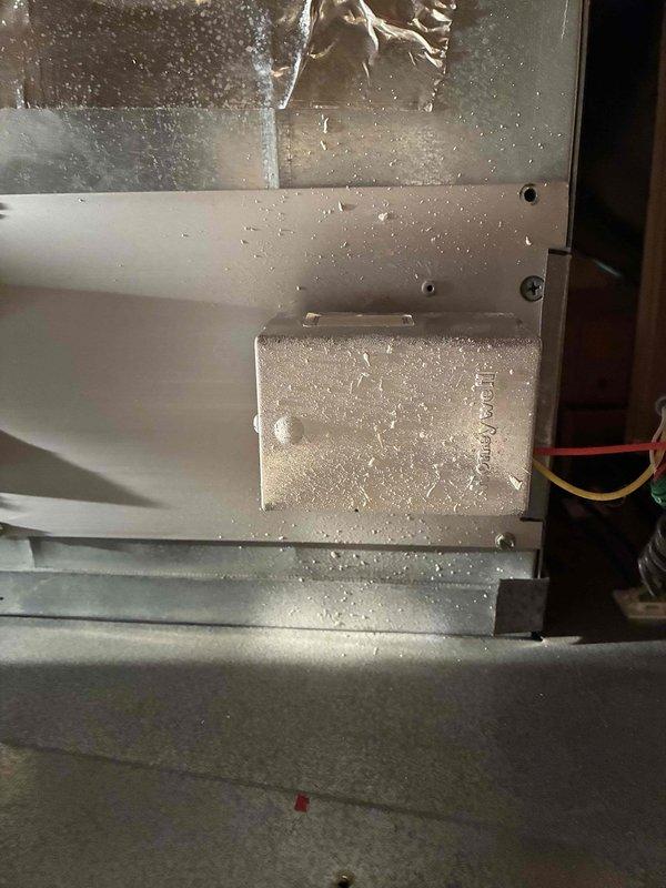 Responded to customer complaint of one bedroom freezing while other areas remained warm. Upon inspection, discovered extensive frost and ice buildup on interior evaporator coil and surrounding components, indicating restricted airflow or low refrigerant condition. The heavy frost accumulation confirmed inadequate heat exchange and explained the temperature imbalance throughout the home. Documented conditions with photos showing crystalline ice coating on metal surfaces, coil assembly, and internal panels. Assessed zoning system operation and airflow distribution. Advised customer of findings and discussed potential tune-up service for further system evaluation and maintenance.