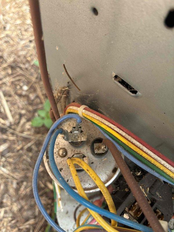 # HVAC Service Call - No Cooling Condition

Responded to a no cooling complaint on a residential air conditioning system over 10 years old. Upon arrival, located the outdoor condensing unit positioned on a concrete pad adjacent to the building structure. Performed visual inspection of the equipment exterior, noting the unit's age and general condition.

Conducted electrical diagnostics at the outdoor unit's terminal block and connection points. Inspected all wire terminations including the common, compressor, fan motor, and capacitor connections. Checked for proper voltage supply to the unit and verified integrity of electrical connections at the terminal board. Examined the condition of wiring insulation and terminal tightness, noting signs of age-related wear and outdoor environmental exposure on electrical components.

Assessed the condensing unit's physical condition, including the condenser coil fins, protective grille, and overall structural integrity. Verified unit placement and