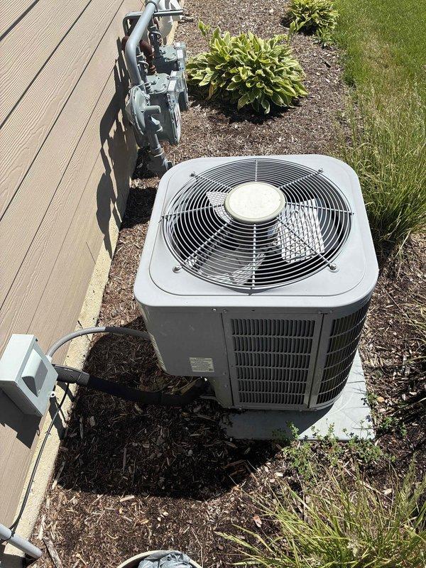 # HVAC Service Call - No Cooling Condition

Responded to a no cooling complaint on a residential air conditioning system over 10 years old. Upon arrival, performed diagnostic evaluation of the outdoor condensing unit located in the side yard. Inspected the condenser unit which showed signs of age and lack of recent maintenance, with visible dust accumulation and spider webs present in the electrical compartment.

Accessed the electrical control panel and identified a failed dual-run capacitor rated at 40/5µF, 440VAC. The capacitor showed signs of deterioration and was determined to be the root cause of the no cooling condition, preventing the compressor and condenser fan motor from operating properly. 

Removed the defective capacitor and replaced it with a new dual-run capacitor meeting the manufacturer's specifications. Reconnected all electrical wiring to proper terminals, ensuring secure connections on both the compressor (HERM) and fan motor (FAN) circuits. Verified proper wire ro
