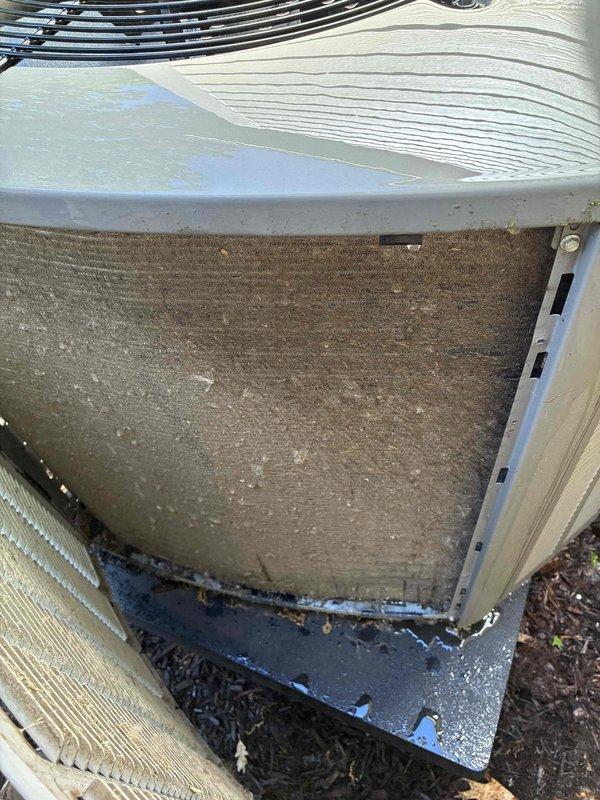# HVAC Service Report - No Cooling/System Freezing

Responded to service call for 10+ year old HVAC system experiencing no cooling condition with evaporator coil freezing. Upon arrival, performed comprehensive system evaluation to identify root cause of refrigeration issue.

Inspection revealed severely restricted airflow as primary failure point. Return air filter was completely blocked with heavy accumulation of dirt, dust, and debris, restricting system airflow to critical levels. Filter contamination was severe enough to cause significant reduction in air velocity across evaporator coil, resulting in coil temperature drop below freezing point and ice formation.

External condenser unit examination showed outdoor coil fins heavily clogged with dirt, organic matter, and environmental debris, particularly concentrated in lower sections of heat exchanger. This contamination further compromised system heat rejection capacity and overall efficiency. White mineral deposits and water stain