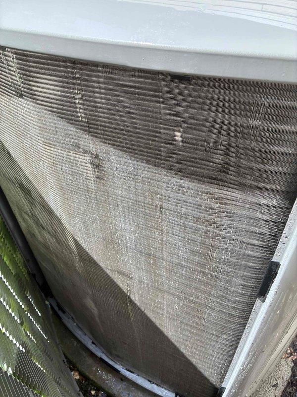 # HVAC Service Report - No Cooling/System Freezing

Responded to service call for 10+ year old HVAC system experiencing no cooling condition with evaporator coil freezing. Upon arrival, performed comprehensive system evaluation to identify root cause of refrigeration issue.

Inspection revealed severely restricted airflow as primary failure point. Return air filter was completely blocked with heavy accumulation of dirt, dust, and debris, restricting system airflow to critical levels. Filter contamination was severe enough to cause significant reduction in air velocity across evaporator coil, resulting in coil temperature drop below freezing point and ice formation.

External condenser unit examination showed outdoor coil fins heavily clogged with dirt, organic matter, and environmental debris, particularly concentrated in lower sections of heat exchanger. This contamination further compromised system heat rejection capacity and overall efficiency. White mineral deposits and water stain