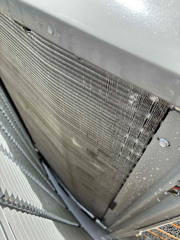 Completed prepaid maintenance visit on air conditioning system. Inspected evaporator coil assembly and found significant dust and debris accumulation on filter media and coil fins, with visible dirt buildup affecting airflow efficiency. Documented moisture present on coil surfaces indicating active condensation during operation. Photographed heavily contaminated air filter showing matted fibrous material and particulate matter throughout filtering surface. Observed dirt streaking across evaporator coil fins, particularly concentrated in center sections, while some areas remained cleaner. System operational at time of inspection with condensation visible on housing components. Customer enrolled in annual quality plan providing parts and filter discount benefits.