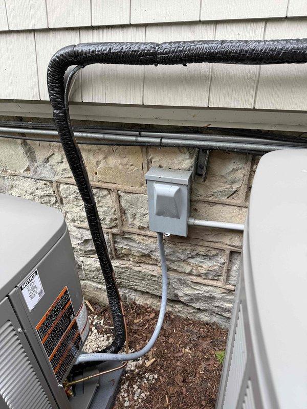 Completed full HVAC system installation including furnace, air conditioning condenser, and evaporator coil. Installed dual outdoor condenser units with proper refrigerant line sets, electrical conduit, and junction box connections mounted to exterior masonry wall. Charged system with refrigerant, verified proper pressures using manifold gauges, and tested all components for proper operation.
