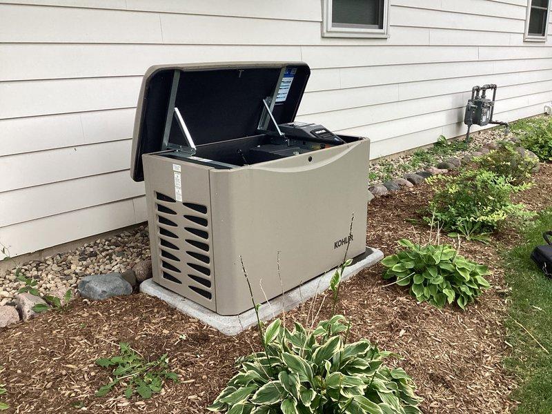 Performed inspection on residential Kohler standby generator unit to investigate reported oil leak. Upon examination with top cover opened, confirmed presence of active oil leak from internal components. Documented condition through photographs showing generator installation on concrete pad with proper clearances maintained. Reviewed system for additional concerns and provided customer with repair recommendations. Scheduled follow-up appointment to complete necessary leak repair work.