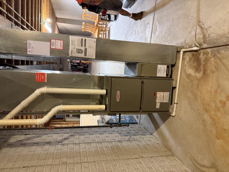 Completed furnace replacement in 1870 square foot ranch home. Removed existing "B" width furnace and installed new unit with proper electrical connections to Square D QO panel, including dedicated 15-amp circuit for furnace and 30-amp circuit for AC system. Replaced 25 feet of 2-inch cellular core PVC venting material for combustion air and exhaust. Reused existing return air drop and media filter cabinet to maintain air quality system. Connected to existing 35-foot refrigerant line set for compatibility with air conditioning system. Verified all gas line connections, tested system operation, and confirmed proper airflow throughout. Installation completed in basement mechanical room with all components mounted securely and meeting code requirements.