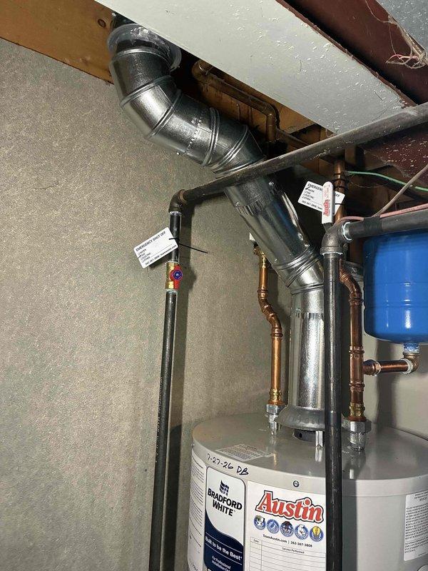 Installed new 4" chimney liner system for water heater venting, including B-vent cap, 3" to 4" reducer, and necessary pipe sections with elbow fittings. Properly secured all ductwork connections through ceiling joists using galvanized metal flange and ensured proper ventilation pathway from water heater to exterior termination point.