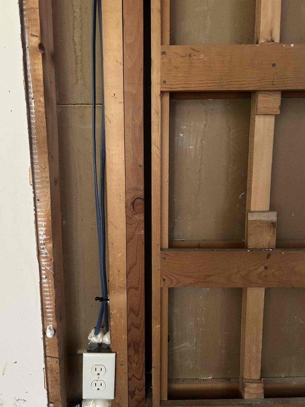 Responded to residential property following small fire incident in first floor living room that resulted in power shutdown to entire home. After main service was reenergized, systematically tested and restored power to all circuits throughout the residence. Conducted comprehensive inspection of all outlets, switches, and lighting fixtures in affected and surrounding areas to verify proper operation and identify any fire-related damage to electrical components. 

Inspected exposed wall cavity in fire-damaged area, documenting extensive heat and smoke damage to interior wall surfaces, framing members, and electrical wiring. Observed charred and discolored wooden studs with visible deterioration from fire exposure. Identified compromised electrical outlet and associated wiring within damaged wall section requiring replacement due to heat exposure and soot contamination. Photographed damaged electrical components and structural conditions for documentation purposes.

Verified all circuits 