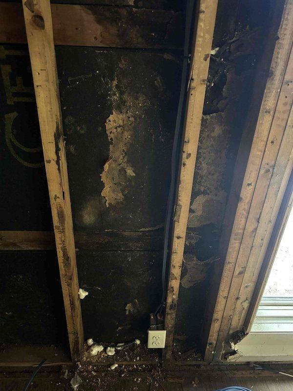Responded to residential property following small fire incident in first floor living room that resulted in power shutdown to entire home. After main service was reenergized, systematically tested and restored power to all circuits throughout the residence. Conducted comprehensive inspection of all outlets, switches, and lighting fixtures in affected and surrounding areas to verify proper operation and identify any fire-related damage to electrical components. 

Inspected exposed wall cavity in fire-damaged area, documenting extensive heat and smoke damage to interior wall surfaces, framing members, and electrical wiring. Observed charred and discolored wooden studs with visible deterioration from fire exposure. Identified compromised electrical outlet and associated wiring within damaged wall section requiring replacement due to heat exposure and soot contamination. Photographed damaged electrical components and structural conditions for documentation purposes.

Verified all circuits 