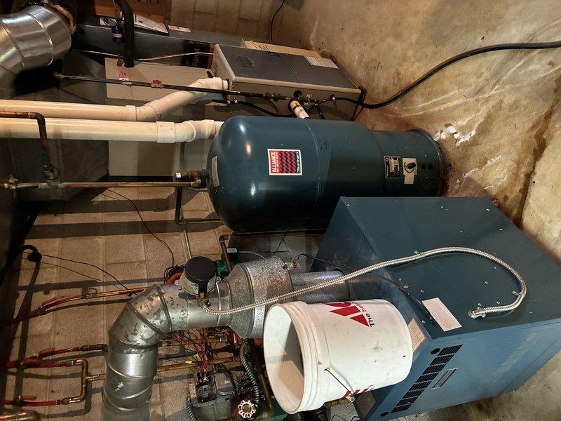 Responded to service call for leaking Burnham indirect-fired water heater connected to boiler system. Upon inspection, confirmed active leak at water heater unit and identified additional plumbing components requiring attention, including deteriorated piping connections and compromised valve assemblies beneath ceiling-mounted infrastructure. Documented equipment conditions through photography, noting moisture damage to surrounding areas and age-related deterioration of brass fittings and gate valves. Prepared comprehensive quote for water heater replacement and necessary ancillary repairs to restore system integrity.