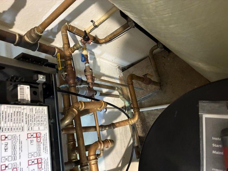 Responded to emergency service call for boiler system displaying fault code 101 related to indirect water heater malfunction. Performed diagnostic inspection of heating system, including examination of three-way valve operation and boiler components. Documented existing piping configuration, pump assembly, and control panel conditions through photographic evidence. Contacted technical support to confirm diagnosis and ordered necessary replacement parts. System evaluation indicates potential pump failure as primary cause of recurring shutdown issues, requiring part arrival before repair completion can proceed.