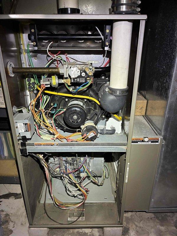 Responded to a no-heat, no-cooling call on a 10+ year old gas furnace. Inspected the furnace with access panels removed, including the inducer motor, pressure switch, gas valve, burner assembly, and control board wiring, and verified the Honeywell thermostat settings and operation (indoor temperature 80°). Diagnostics were performed on the heating and cooling control circuits to restore system operation.