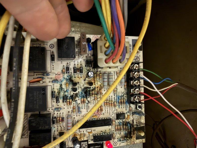 Responded to an emergency no-heat call on a 20-year-old furnace and diagnosed a failed integrated control board, with visible corrosion, contamination, and scorching across the board components and solder joints. The failed board prevented system operation, and the unit's age was weighed against options of board replacement or full furnace replacement.