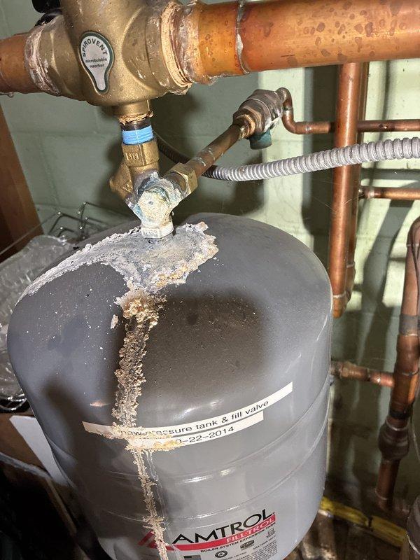 Performed a pre-winter inspection of the gas-fired hydronic boiler system in response to reported inadequate heating and a slow leak. Found the original 2014 Amtrol expansion tank leaking at the top fitting, with heavy corrosion and mineral buildup on the tank and surrounding copper piping and fittings, and noted water staining at the base of the boiler. Documented conditions with photos; the expansion tank and other components require replacement, and a repair quote is being prepared.