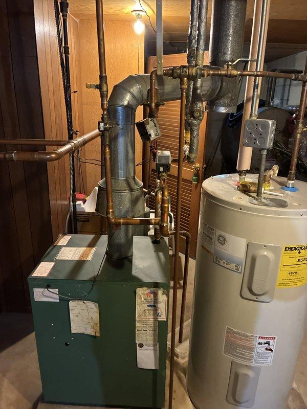 Responded to a boiler leak on startup and diagnosed the expansion tank and pressure relief valve as failed and the source of the leak. Inspected the boiler piping, flue, zone valves, and discharge line, with a drip tray in place to contain discharge. Documented system conditions with photos and prepared a repair quote for replacement of the expansion tank and relief valve.