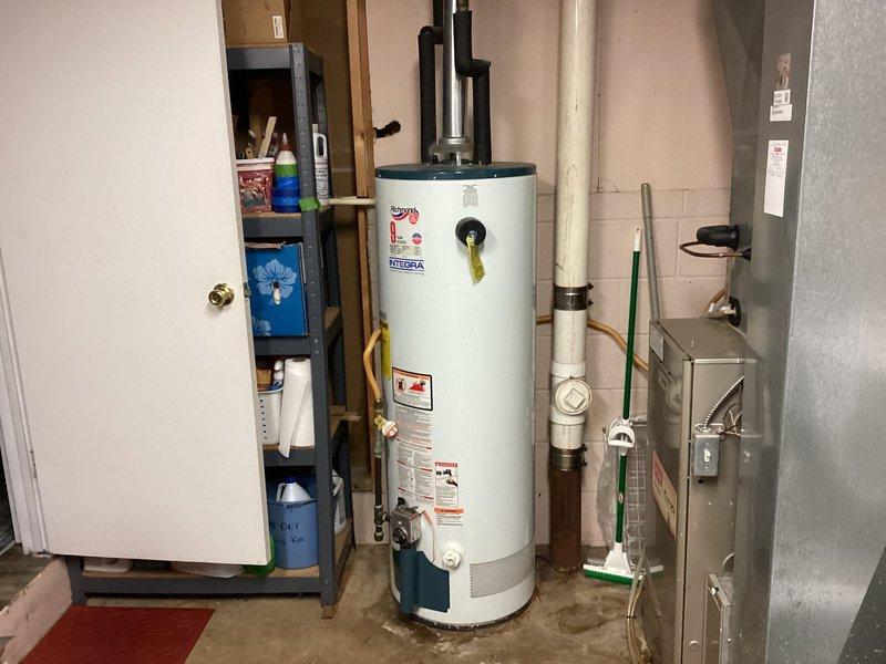 Performed a full inspection of a leaking Richmond Integra gas tanked water heater and found moisture and staining on the concrete floor at the base of the unit, confirming the tank has failed and is beyond economical repair. Recommended replacement of the water heater and provided a quote for the replacement unit.