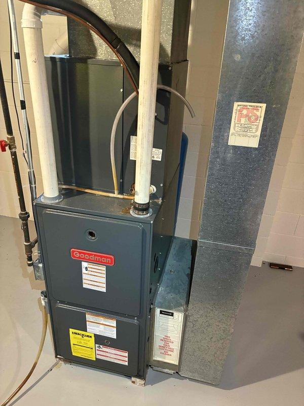 Performed a seasonal heating tune-up on an 11-year-old Goodman gas furnace, inspecting the cabinet, venting, and condensate and PVC flue connections and checking components related to the customer's reported intermittent ignition. Verified proper operation of the unit and surrounding ductwork, and found no visible rust, cracks, or damage; the system is ready for the heating season.