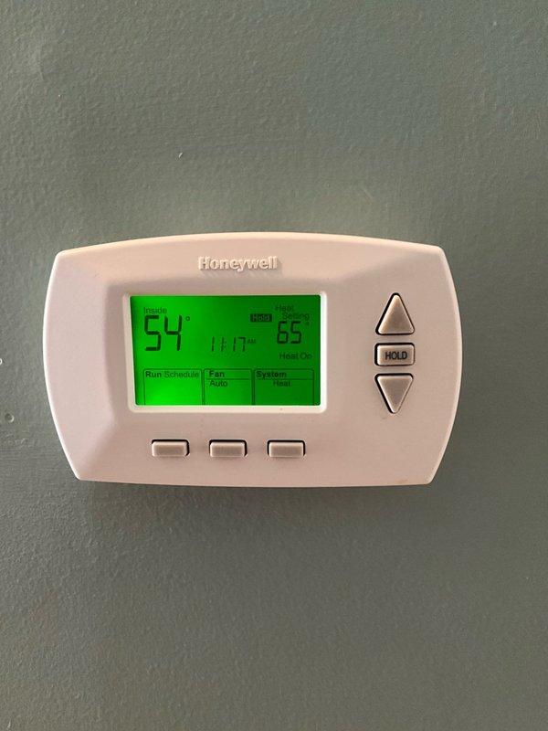 Responded to no-heat call for upstairs apartment furnace. Upon arrival, found thermostat functioning properly but displaying low indoor temperature (54°F) with 65°F set point. Inspection of furnace revealed faulty ignition module preventing system operation. Replaced ignition module, cleaned flame sensor, and verified proper ignition sequence. System now operating correctly and producing adequate heat.