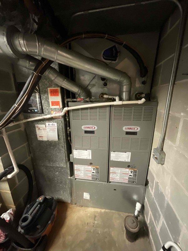 Completed site assessment for replacement of twin Lennox furnace units showing significant age deterioration, along with corresponding AC systems. Documented existing installation configuration including ductwork layout, refrigerant lines, and air handler positioning in concrete block utility room. Measurements and specifications were recorded to prepare comprehensive quote for full commercial HVAC system replacement.