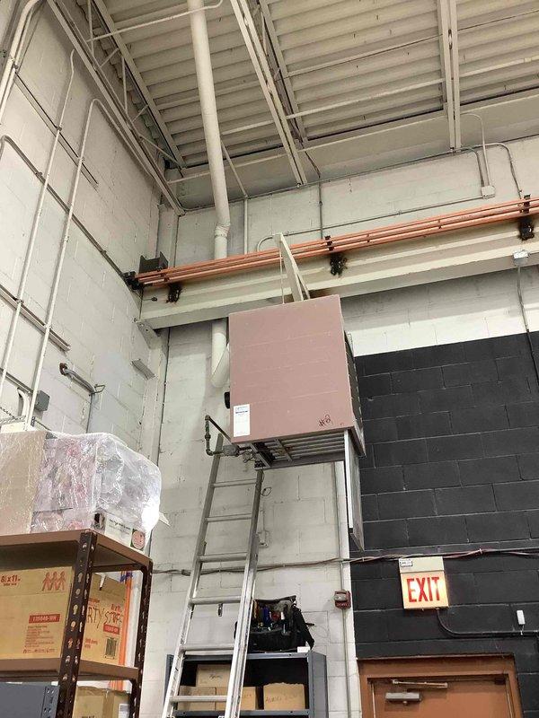 Responded to commercial no heat call for unit #9 that was previously serviced earlier this month. Performed diagnostic inspection of the wall-mounted HVAC system located in the storage/utility area. Accessed unit using ladder to reach the elevated equipment, verified proper operation, and restored heating functionality by adjusting control settings that had been improperly modified.