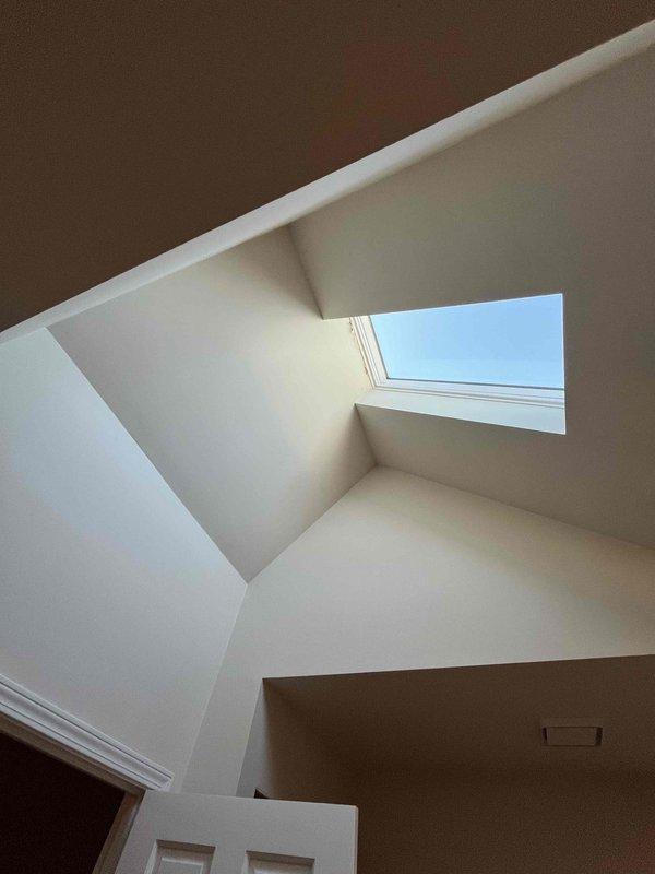 Conducted inspection of exhaust fan system requiring replacement as noted in service history. Documented significant deterioration of surrounding insulation material with visible debris accumulation. Skylight installation appears intact and functioning properly, but exhaust system shows signs of failure requiring complete unit replacement.