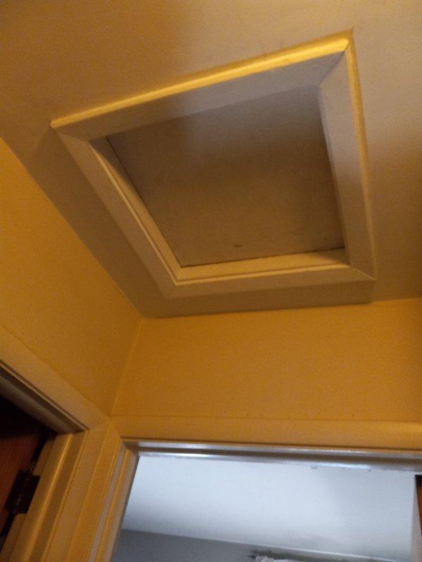 Accessed attic space via ceiling hatch to inspect kitchen exhaust vent line. Confirmed proper installation and connection of galvanized metal vent pipe running through wooden structural members. Verified ventilation pathway is clear and functioning as intended.