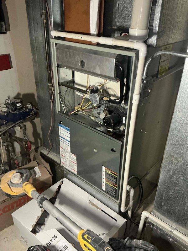 Performed comprehensive inspection and evaluation of client's aging HVAC system (22+ years old) at commercial property. Documented existing equipment including furnace with deteriorating internal components and two outdoor AC condensers (one white, one gray) mounted on concrete pad against brick exterior. Prepared detailed replacement estimate for one complete furnace/AC system set, noting client has three total systems but is prioritizing replacement of one unit during ongoing construction at the property.