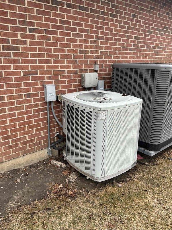 Performed comprehensive inspection and evaluation of client's aging HVAC system (22+ years old) at commercial property. Documented existing equipment including furnace with deteriorating internal components and two outdoor AC condensers (one white, one gray) mounted on concrete pad against brick exterior. Prepared detailed replacement estimate for one complete furnace/AC system set, noting client has three total systems but is prioritizing replacement of one unit during ongoing construction at the property.