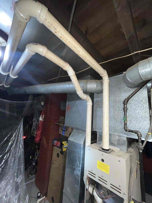 Conducted comprehensive assessment of aging furnace system in basement utility area. Found existing unit operational but with significant reliability concerns. Inspection revealed potential issues with ventilation system, including PVC pipe configuration and metal ductwork connections. Recommended replacement options to improve reliability and efficiency based on current installation constraints.