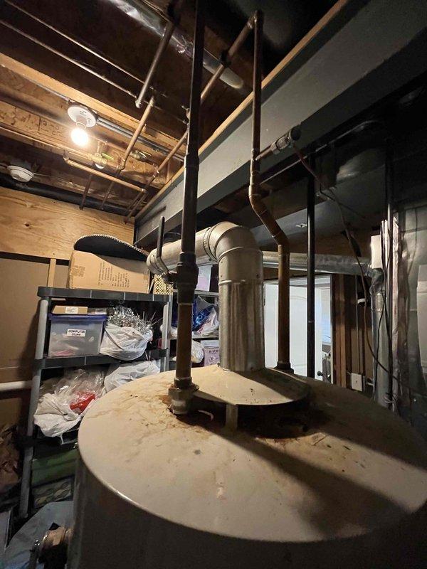 Responded to "No Hot Water" service call at residential property. Inspected aging tanked water heater in unfinished basement with copper supply lines and visible signs of deterioration. Diagnosed and resolved issue, restoring hot water functionality to the home.