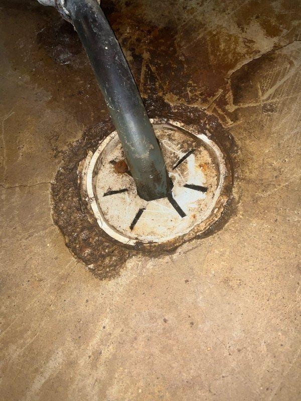 Upon inspection of the 15-year-old furnace, identified water leakage issues evidenced by significant staining and moisture damage on the concrete floor surrounding the unit. Evaluated the drainage system, noting mineral deposits and sediment buildup around the floor drain, and confirmed proper connection of the PVC condensate line to the drainage system.