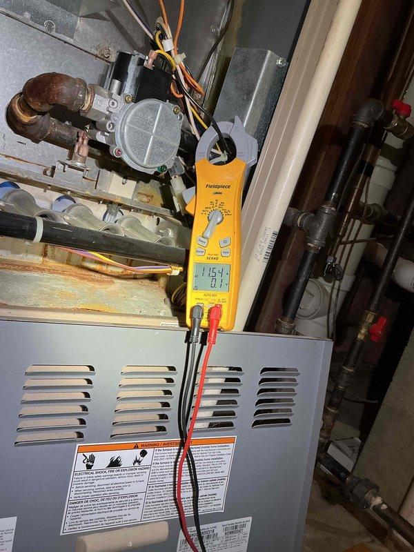 Responded to no-heat call for 2-year-old furnace that was cycling on and off. Diagnostic testing with Fieldpiece meter revealed reading of 11.59 when testing control board voltage. Inspection of heat exchanger showed significant rust and corrosion on internal components, particularly around burner tubes and connection points, indicating premature failure requiring replacement.