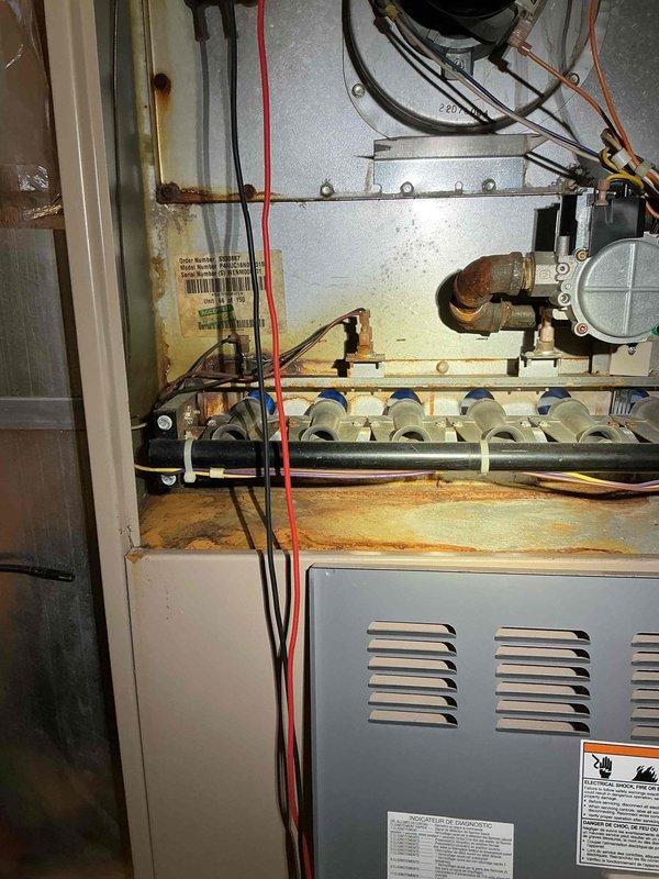 Responded to no-heat call for 2-year-old furnace that was cycling on and off. Diagnostic testing with Fieldpiece meter revealed reading of 11.59 when testing control board voltage. Inspection of heat exchanger showed significant rust and corrosion on internal components, particularly around burner tubes and connection points, indicating premature failure requiring replacement.