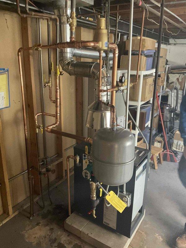 Successfully installed a Weil McLain CGA-4 boiler system with expansion tank in residential basement. Completed all necessary copper pipe connections with 1" and 3/4" fittings, and properly pressurized the system. System functionality verified with all components operating as designed.