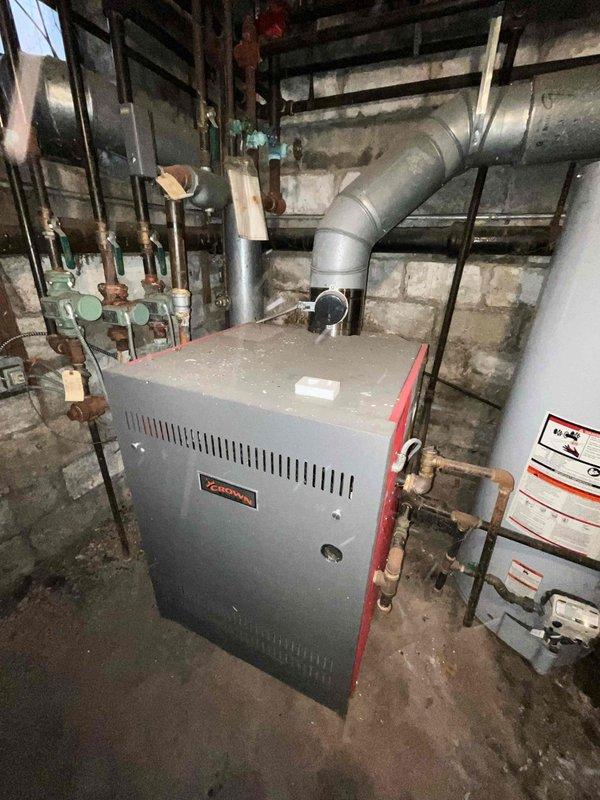 Successfully replaced the main control circuit board in Crown boiler that was previously staged at headquarters. Documented the installation with photos showing the A.O. Smith water heaters and Lennox heating system in the utility area. System is now operational with all connections properly secured.
