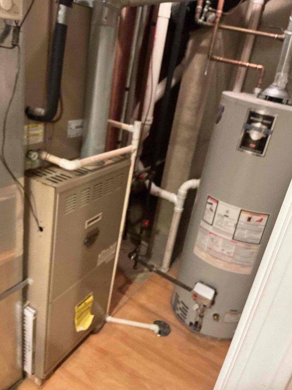 Responded to after-hours call for heating system failure in 1990s model equipment that had been previously serviced without resolution. Performed diagnostic inspection of both the indoor furnace unit and outdoor condenser, documenting the condition of the mechanical room setup including water heater integration and associated PVC/copper piping network. System requires follow-up service due to age-related component deterioration.