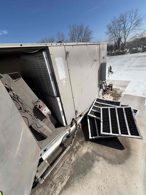 Completed scheduled commercial BFMA tune-up service on rooftop HVAC unit, which included replacement of nine air filters. Removed and installed new filters with white plastic frames, ensuring proper fit and airflow. Visual inspection confirmed system components were in working order following maintenance.