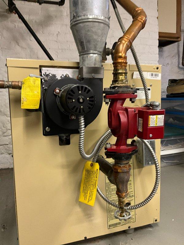 Performed diagnostic service on 2015 Action-installed boiler that was leaking onto floor. Inspection revealed corrosion at copper pipe connection points to circulation pump, with visible discoloration at several fitting joints. Identified failed seal at pump assembly as source of water leakage.