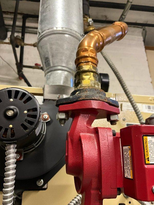 Performed diagnostic service on 2015 Action-installed boiler that was leaking onto floor. Inspection revealed corrosion at copper pipe connection points to circulation pump, with visible discoloration at several fitting joints. Identified failed seal at pump assembly as source of water leakage.