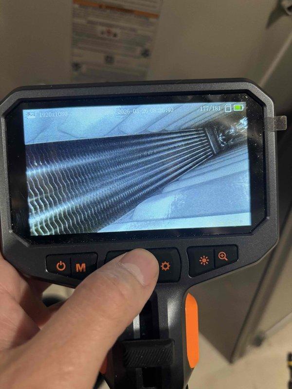 Performed comprehensive heat exchanger inspection on 8+ year old HVAC unit using borescope camera equipment. Conducted thorough visual examination of internal heat exchanger surfaces and evaporator coil fins to assess condition and identify any signs of deterioration, cracking, or potential safety concerns. All components were accessible and inspected without complications, with detailed photographic documentation captured for service records.