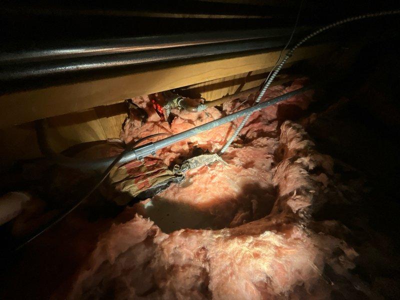 Responded to service call for non-functioning exterior water spigot where one of two spigots was not flowing. Accessed crawl space/attic area to locate and inspect supply line routing through insulation and structural framing. Identified issue with water supply to affected fixture, performed necessary repairs to restore proper water flow to the inoperative spigot, and verified system operation upon completion.