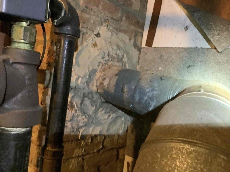 Conducted comprehensive site assessment for boiler replacement estimate at residential property. Evaluated existing hydronic heating system components including zone valves, circulation pumps, and associated piping infrastructure located in attic space. Documented current system conditions showing aged flexible ductwork connections, deteriorated insulation backing on surrounding framing, and existing brass valve assemblies with filtration components. Assessed accessible plumbing connections, PVC venting configuration, and mechanical equipment placement for replacement specifications. Photographed installation area to determine proper equipment sizing, clearance requirements, and integration points for new boiler system.