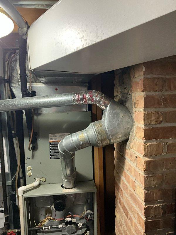 Completed comprehensive furnace tune-up on 16+ year old residential heating system located in basement mechanical room. Performed full preventative maintenance inspection including cleaning and testing of all major components, verified proper operation of burners and heat exchanger, checked gas connections and pressures, inspected and cleaned blower assembly, tested safety controls and limit switches, examined venting system and flue pipe connections to brick chimney, and confirmed adequate airflow through ductwork system. All components found to be functioning within acceptable parameters at time of service. Provided client with quote information for future furnace and air conditioning replacement system as requested.