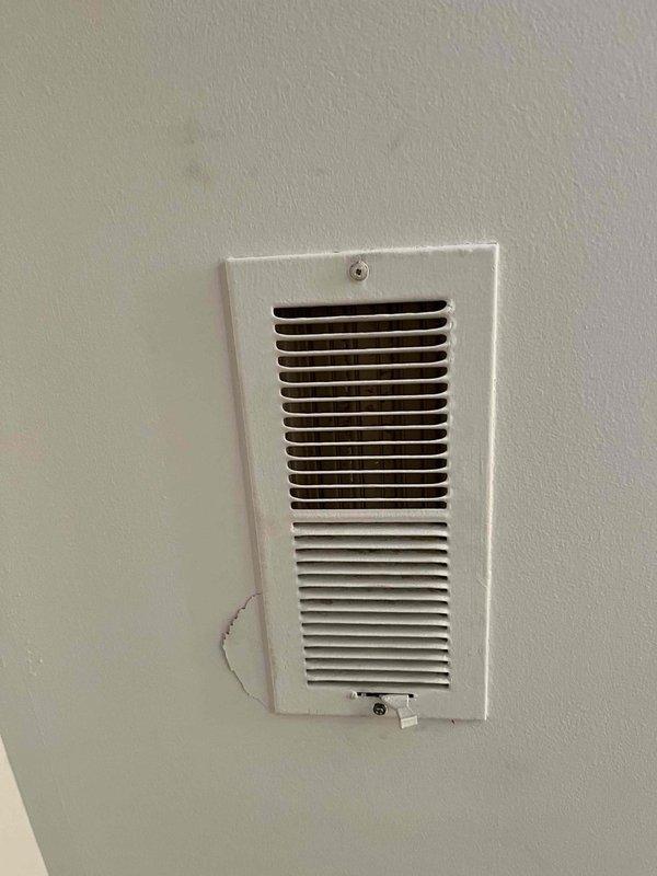 Completed callback service for register installation quality concerns. Cleaned all visible fingerprints and palm prints from register cover, secured mounting screw that was not fully tightened, and re-bent register louvers to ensure proper fit and flush mounting against ceiling surface. All adjustments verified and unit left in proper working condition.