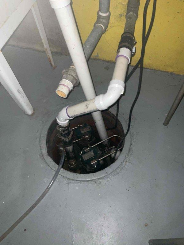 Completed spring AC tune-up and preventative maintenance inspection for Bluefrost member. Inspected and serviced air conditioning system, verified all components operating within normal parameters. Replaced air filter with new pleated media filter to ensure proper airflow and system efficiency. Documented sump pump installation and associated drainage system in basement utility area, noting proper operation of pump mechanism and PVC piping configuration. All systems tested and confirmed operational.