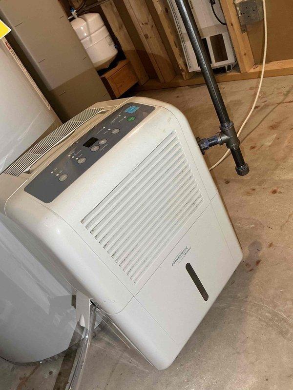 Completed comprehensive BFMA tune-up service on 5-month-old furnace and humidifier system in morning timeframe as requested. Performed full system diagnostics using digital multimeter to verify electrical readings and component functionality, measuring voltage at 146.24V during testing. Inspected furnace operation, checked all safety controls, verified proper airflow, and examined condensate drain lines with PVC piping secured appropriately. Evaluated portable dehumidifier unit positioned in unfinished basement area, confirming operational status with control panel indicators displaying proper function. All equipment found operating within manufacturer specifications with no issues identified during inspection.