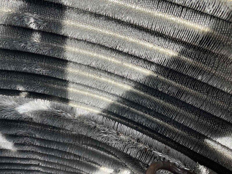 Completed comprehensive BFMA tune-up service on 8+ year old air conditioning system during afternoon appointment window. Performed thorough inspection of evaporator coil assembly, which revealed significant accumulation of dust, lint, and fibrous debris throughout the fin structure requiring attention. Inspected air filter component showing pleated media in acceptable condition with minimal contamination. Conducted standard tune-up procedures including system performance evaluation, operational testing, and documentation of equipment condition with photographic records for maintenance history.